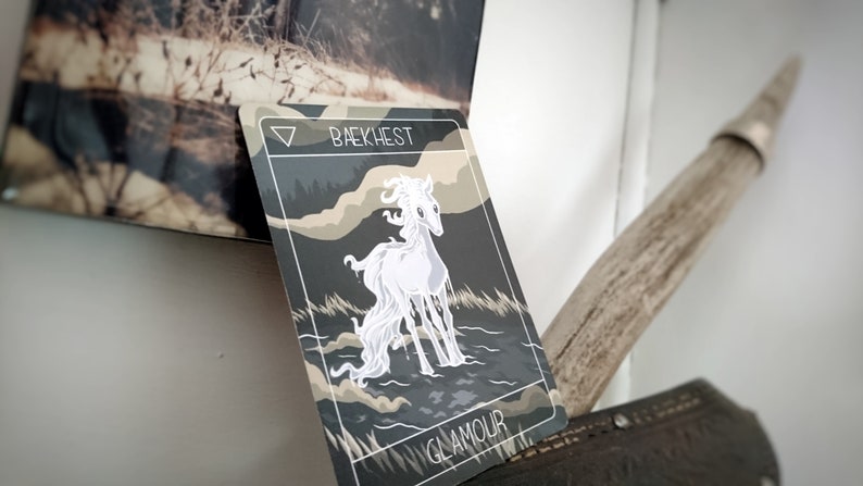 May include: A white horse with a flowing mane stands in a dark, misty forest. The card is titled "Baekhest" and "Glamour" in white text.
