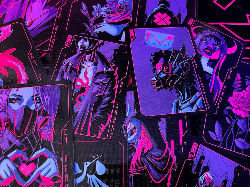 K&ouml;nnte beinhalten: Ein Kartenspiel mit Cyberpunk-&Auml;sthetik. Die Karten zeigen Illustrationen in Lila, Pink und Schwarz. Jede Karte hat ein einzigartiges Design, darunter Figuren mit Masken und futuristischen Elementen. Die Karten sind auf einer dunklen Oberfl&auml;che verstreut.
