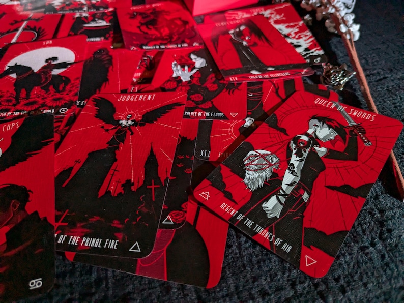May include: A set of tarot cards with red backgrounds and black illustrations. The cards feature titles such as "Judgement", "Palace of the Floods", "Regent of the Thrones of Air", and "Queen of Swords".