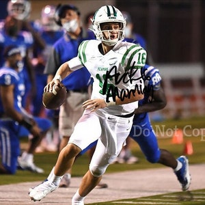 May include: A football player in a white and green uniform runs with the ball. He is wearing a green helmet with a white stripe. The player is wearing the number 16 on his jersey. The text "Do Not Copy" is visible in the lower right corner of the image.