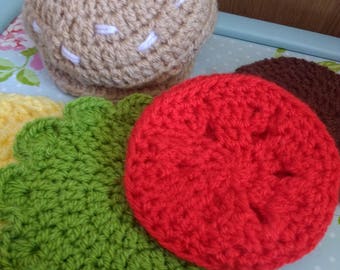 May include: Crocheted hamburger toy set with a brown bun, red tomato, green lettuce, and a yellow cheese slice.