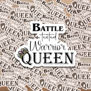 May include: A white sticker with black text that reads "Battle Tested Warrior Queen". The text is in a stylized font and includes a crown graphic. The sticker is surrounded by smaller, repeated stickers with the same text.