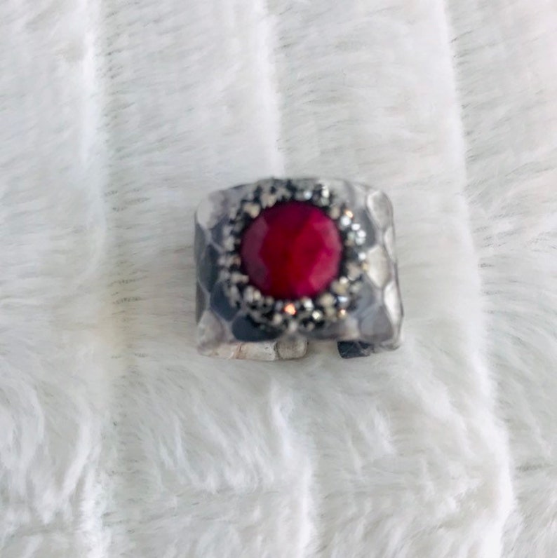 Faceted red garnet ring with druzys set in a grey shaded python adjustable band.