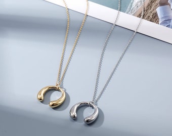 High polish horseshoe shaped pendant on a delicate link chain in yellow or white gold plating