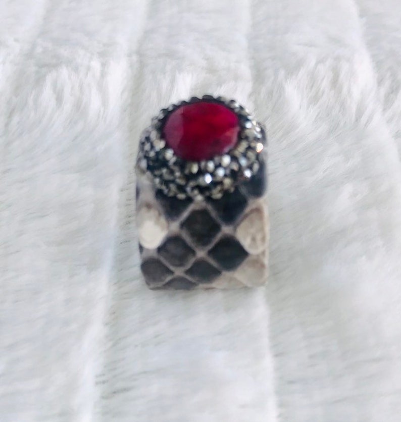 Faceted red garnet ring with druzys set in a grey shaded python adjustable band.