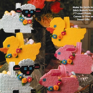 May include: A collection of six quick-stitch baskets made from 7-count plastic canvas. The baskets are shaped like a sheep, duck, and bunny, each adorned with colorful flowers and filled with Easter eggs. The text reads: "Make Six Quick-to-Stitch Baskets from 7-count Plastic Canvas to Give as Sweet Gifts."