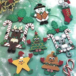 May include: A selection of handmade Christmas decorations, including a snowman, reindeer, Christmas tree, star, bell, and mouse. The ornaments are crafted from yarn and feature festive colours such as red, green, and white. Candy canes and holly accents are also included.