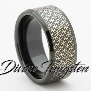 May include: A black tungsten ring with a silver patterned design. The ring is beveled and has a polished finish.