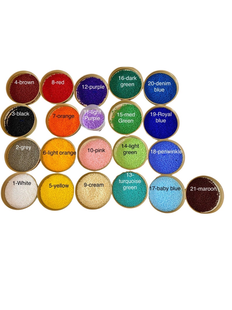 May include: A collection of twenty-one round containers filled with small, uniform beads in various colors, each labeled with a number and color name including white, grey, black, brown, yellow, orange, pink, cream, purple, green, blue, and maroon.