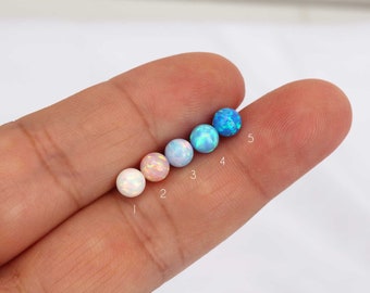 May include: Five opal beads in different colors, ranging from white to light blue. The beads are numbered 1 through 5.