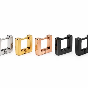 May include: A set of five square-shaped hoop earrings arranged in a row. The earrings feature a hinged closure mechanism and are finished in silver, gold, rose gold, and two variations of black metal tones with a polished surface.