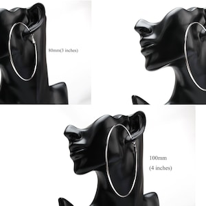 May include: Three silver hoop earrings of different sizes displayed on a black mannequin head. The earrings measure 80mm, 90mm, and 100mm in diameter.