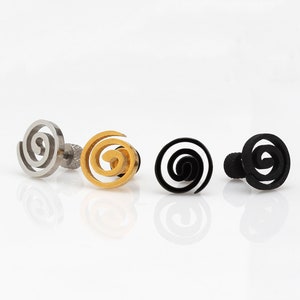 May include: Four pairs of spiral stud earrings in silver, gold, and black.