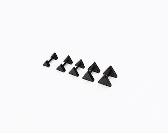 May include: A set of six black triangle stud earrings of varying sizes. The earrings are made of stainless steel and have a polished finish.