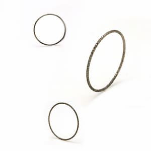 Könnte beinhalten: Drei silberne Ringe mit einer strukturierten Oberfläche. Die Ringe sind alle unterschiedlich groß und in einem dreieckigen Muster angeordnet.