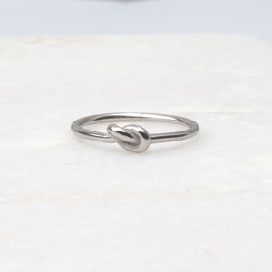 May include: A silver knot ring with a simple design.