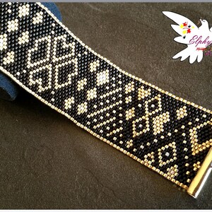 May include: A beaded bracelet in black and gold, featuring a geometric floral design. The bracelet is constructed from small, square beads and has a gold-coloured clasp. The pattern is a repeating motif of black and gold beads.