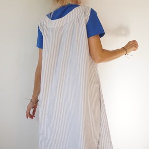 May include: A white and blue striped sleeveless dress with a blue short-sleeved shirt underneath.