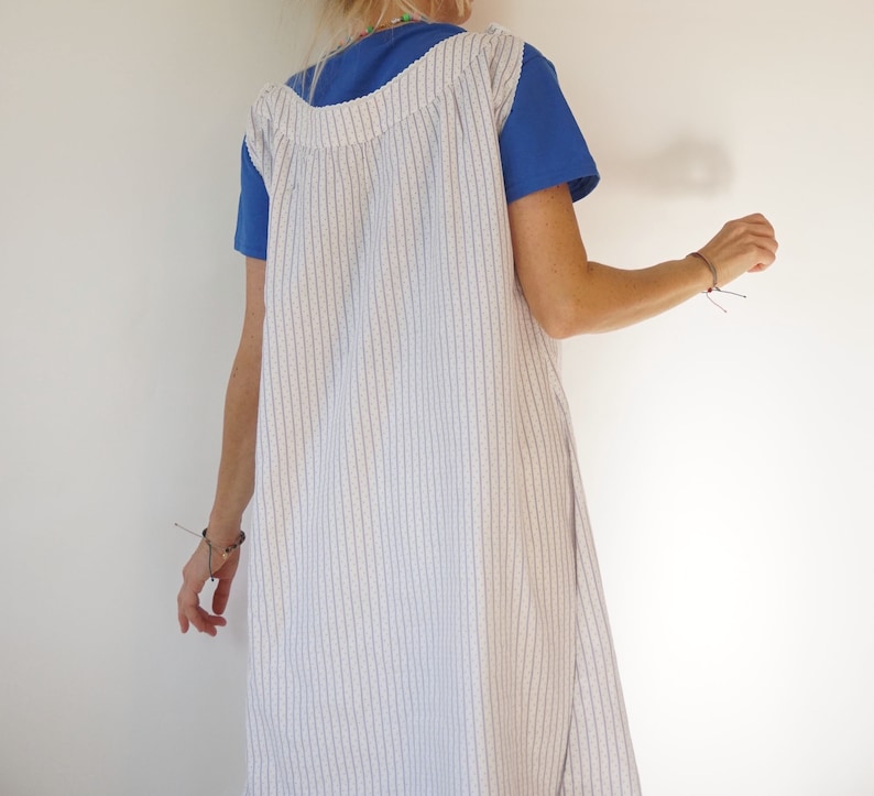 May include: A white and blue striped sleeveless dress with a blue short-sleeved shirt underneath.