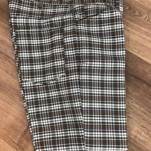 May include: A pair of brown and white plaid pants folded in half. The pants have a blue and white plaid pattern.