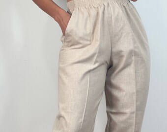 May include: Beige linen pants with a wide waistband and a relaxed fit.