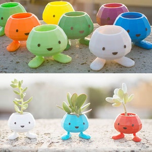 May include: A set of colourful, whimsical planters shaped like cartoon characters with legs. Each planter has a different colour and a cute face. The planters are perfect for small plants or succulents.