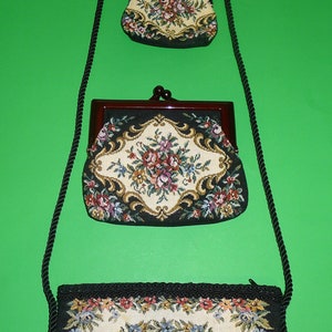 Peut inclure: Un ensemble de trois pochettes en tapisserie florale avec des bordures noires et une bandoulière noire. Les pochettes sont de tailles différentes et ont un aspect vintage.