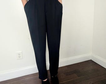 May include: Black high-waisted pants with a straight leg fit. The pants have a center crease and are made of a smooth fabric.