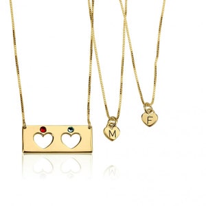 May include: Two gold necklaces with heart pendants. One necklace has a rectangular charm with two cut-out hearts and red and blue gemstones. The other necklace has a heart pendant with the letter "M" on it. The third necklace has a heart pendant with the letter "F" on it.