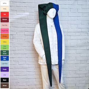 May include: A long, two-toned fabric headpiece featuring a dark green side and a royal blue side, worn on a mannequin. The headpiece has a gathered, elasticized cap section that fits over the head, with two long, pointed fabric tails hanging down.
