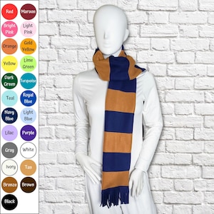 May include: A scarf featuring horizontal stripes in navy blue and tan, finished with fringe at the ends. The image includes a color chart on the left side displaying various circular color swatches labeled with names like Red, Maroon, Pink, and Black.