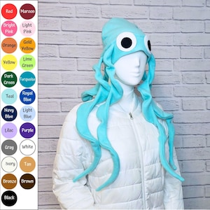 May include: A light blue octopus hat featuring large white and black eyes and dangling tentacles. To the left, a color chart displays twenty circular swatches labeled with names including Red, Maroon, Bright Pink, Light Pink, Orange, Gold Yellow, Yellow, Lime Green, Dark Green, Turquoise, Teal, Royal Blue, Navy Blue, Light Blue, Lilac, Purple, Gray, White, Ivory, Tan, Bronze, Brown, and Black.