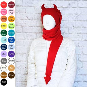 May include: A bright red fleece hat featuring two pointed devil horns on top and a long scarf attachment that hangs down, ending in a pointed devil tail shape. A colour chart on the left displays twenty different colour options with text labels.