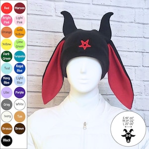May include: A black beanie featuring two upright horns and long, red-lined ear flaps. A red pentagram is embroidered on the front. A size chart is visible with measurements: S 18-20 inches, M 21-24 inches, and L 25-26 inches, alongside a color palette.