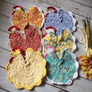 May include: Six crocheted rooster dishcloths in various colors, including yellow, red, blue, and green. The dishcloths are made with a textured stitch and have a scalloped edge.