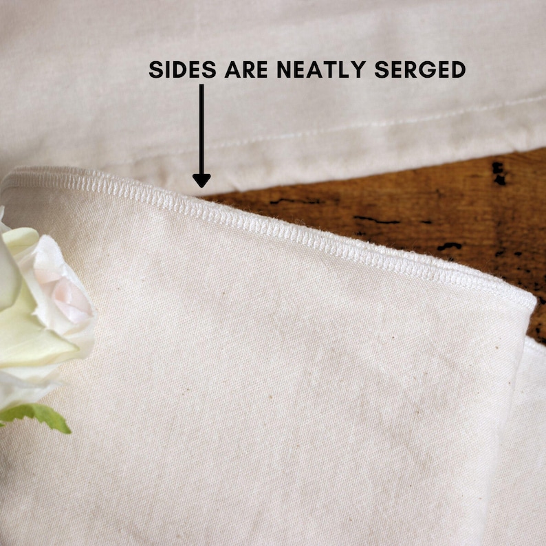 May include: Close-up of a white fabric with a neatly serged edge. The fabric is smooth and has a subtle texture. "SIDES ARE NEATLY SERGED" is written in black text above the fabric.