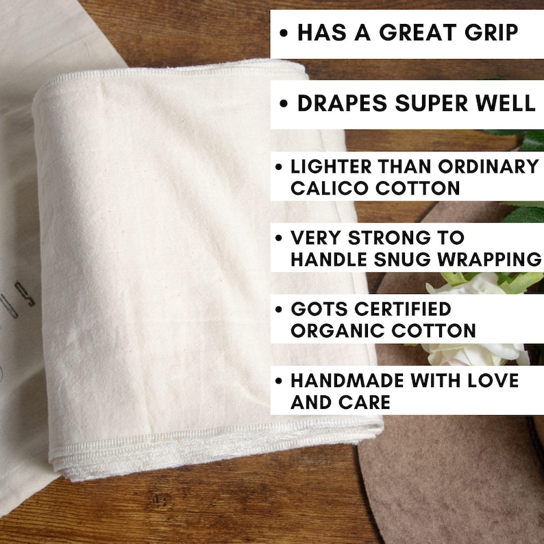 May include: A stack of white organic cotton fabric with a brown hat and white flowers in the background. The fabric is described as having a great grip, draping well, being lighter than calico cotton, strong enough for snug wrapping, GOTS certified, and handmade with love and care.