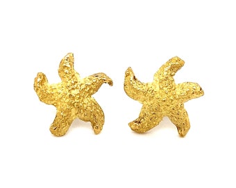 May include: A pair of gold-tone starfish stud earrings. The earrings are textured and have a slightly rough finish.
