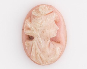 May include: A pink cameo featuring a carved profile of a woman's face.