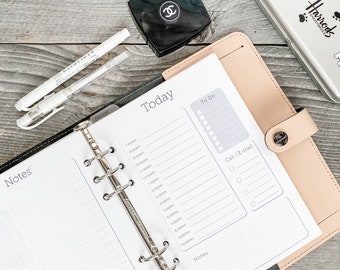 May include: A black and beige leather bound planner with a silver ring binder. The planner has a section for "Today" and a section for "To Do". The planner also has a section for "Notes" and a section for "Call/E-mail".