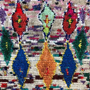 May include: A colorful Moroccan rug with a geometric pattern. The rug is made of wool and has a variety of colors, including red, blue, green, yellow, and orange.