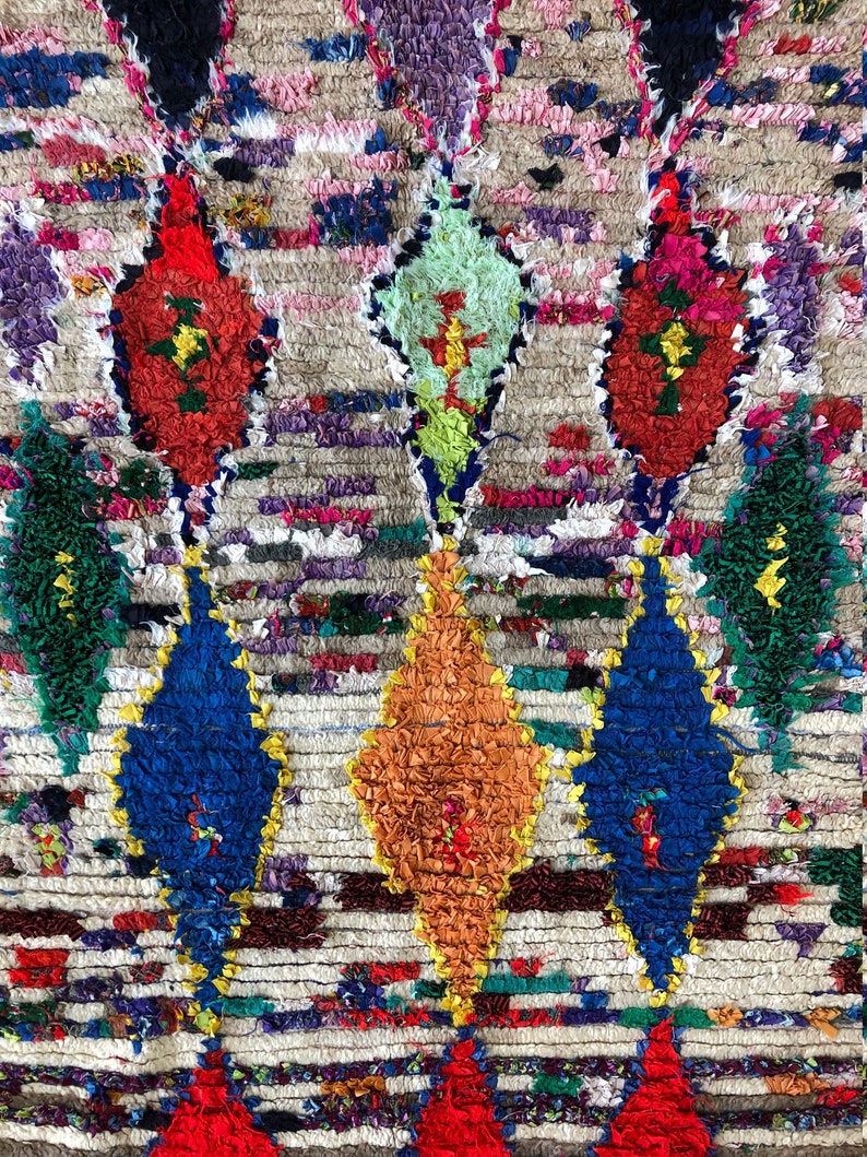 May include: A colorful Moroccan rug with a geometric pattern. The rug is made of wool and has a variety of colors, including red, blue, green, yellow, and orange.