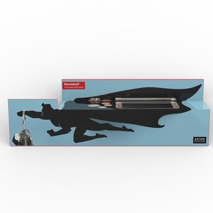Op de afbeelding: Een blauw en zwart Heroshelf met een superheld silhouet ontwerp. De plank heeft compartimenten voor een telefoon, munten en sleutels. De tekst "Heroshelf The small stuff saver" is zichtbaar.