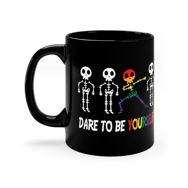 May include: Black coffee mug with a rainbow skeleton design and the text "Dare to be yourself".