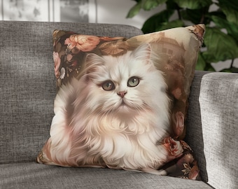 May include: A white Persian cat with green eyes is featured on a throw pillow. The pillow has a floral pattern with pink roses and a vintage background.
