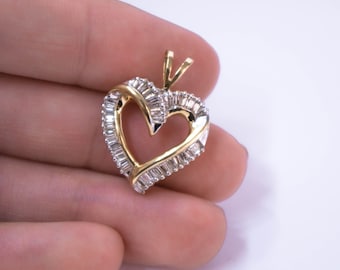 May include: A gold heart-shaped pendant with a diamond-encrusted design. The pendant is set with baguette-cut diamonds.