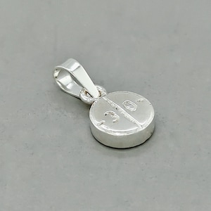 May include: Silver pill charm pendant with a 30 engraved on it.