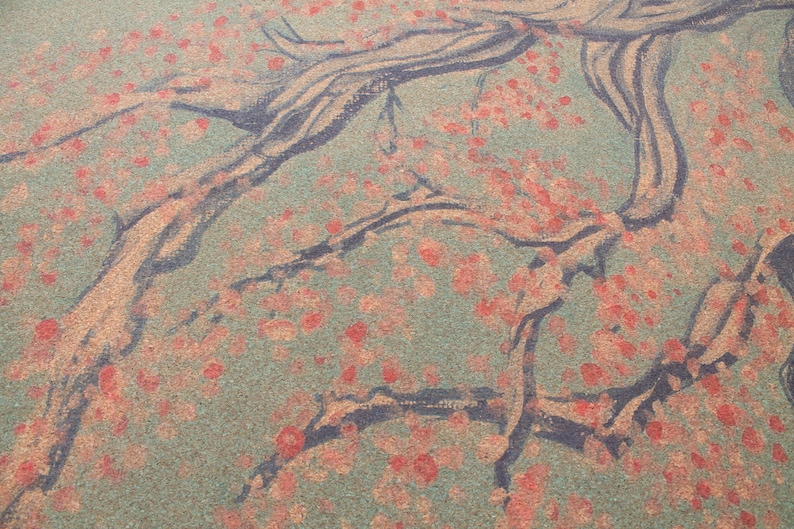 K&ouml;nnte beinhalten: Nahaufnahme einer strukturierten, gr&uuml;n-braunen Oberfl&auml;che mit einem schwarzen, gemalten Design eines Baumes mit &Auml;sten. Der Baum ist mit kleinen roten Punkten bedeckt.