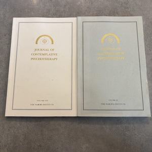May include: Two softcover books titled Journal of Contemplative Psychotherapy, Volume VIII and Volume IX, published by The Naropa Institute. The left book has a white cover, and the right book has a light gray cover, both featuring gold text and logos.