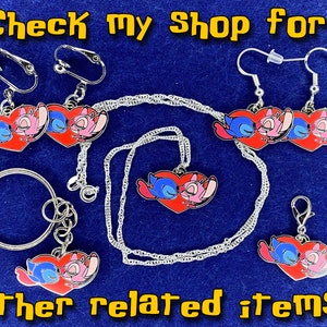 Puede incluir: Un conjunto de joyas con tem&aacute;tica de Stitch y Angel, que incluye aretes, un collar, un llavero y un dije. Las joyas presentan un coraz&oacute;n rojo con Stitch y Angel durmiendo dentro. El texto "Check My Shop for other related items." es visible en la imagen.